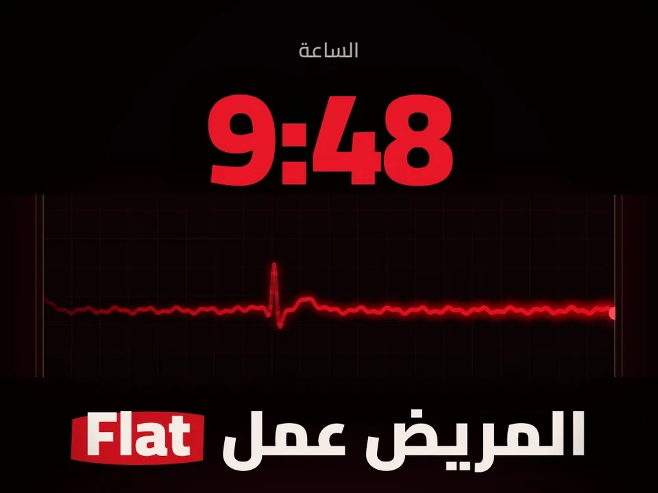 مونيتور مكتوب عليه العيادة، الساعة 9:48 بالأحمر وخط النبض مفرود، وتحته المريض عمل Flat